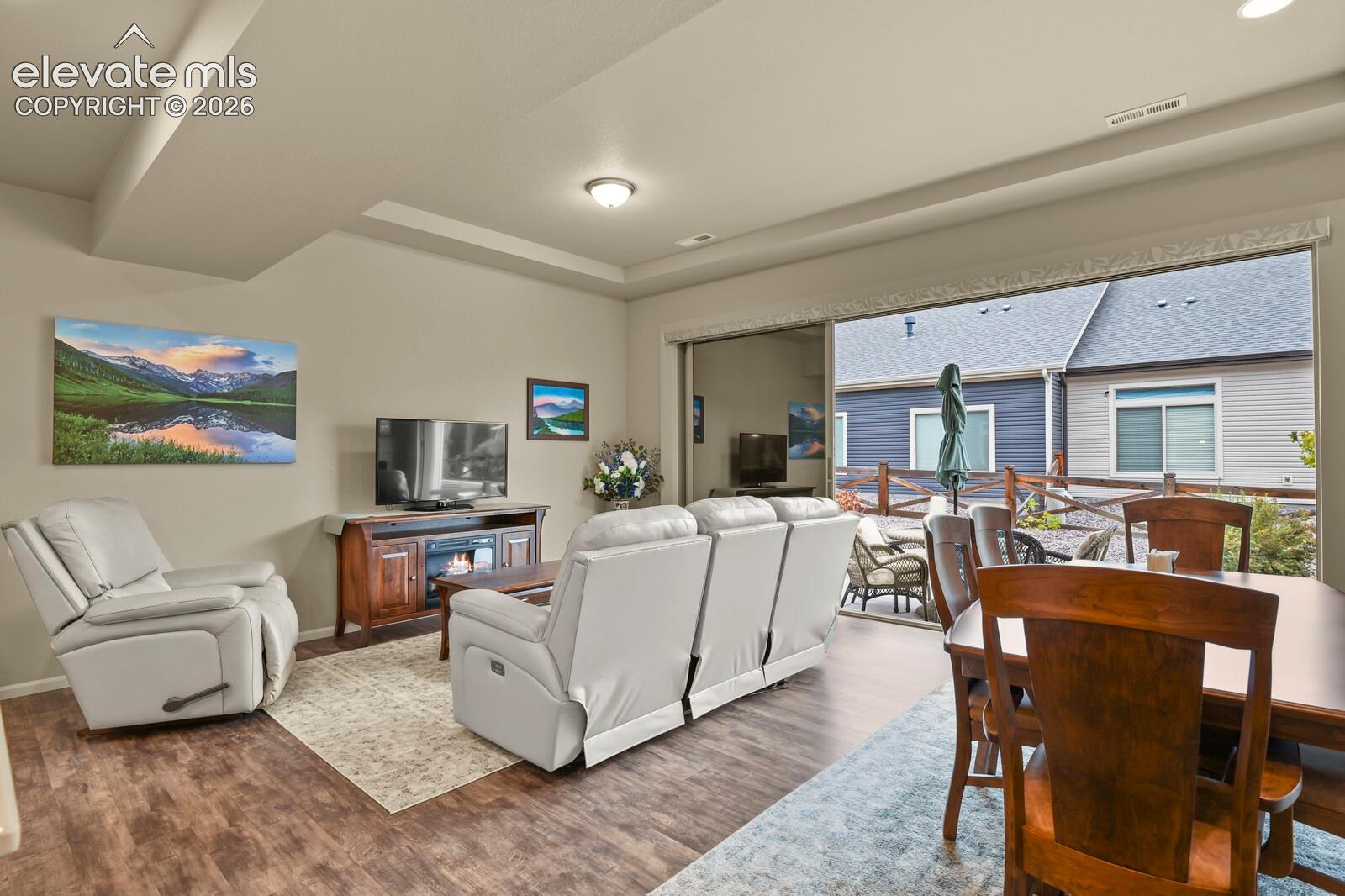 Tray ceiling with recessed lighting and large sliding glass door providing access to the rear exterior