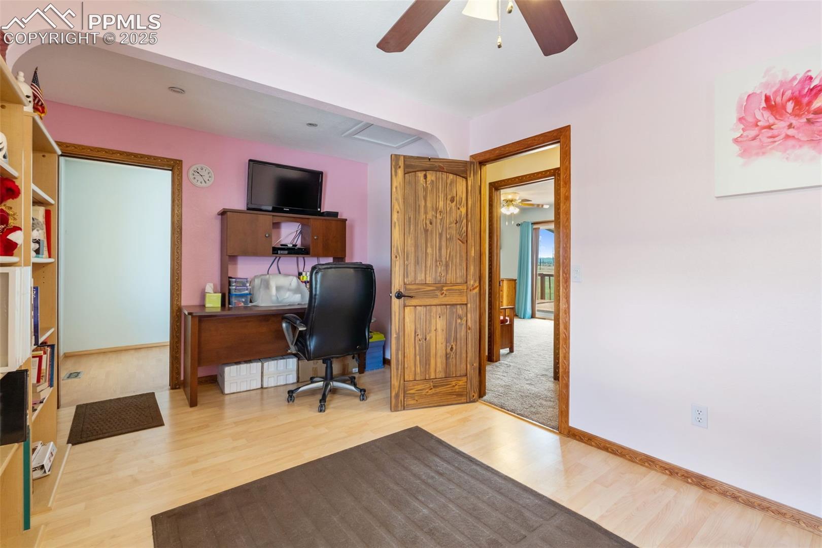 Spacious secondary upper bedroom with ceiling fan and natural light