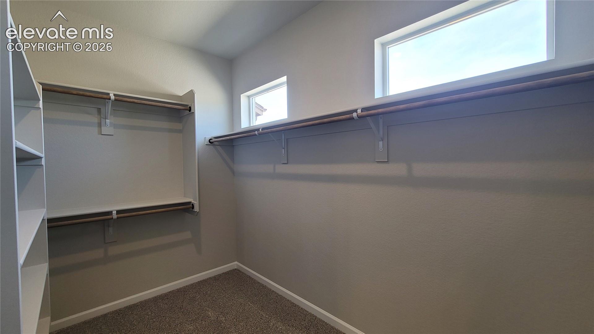1 of 2 Primary Walk-in closets with wood shelving and rods! 