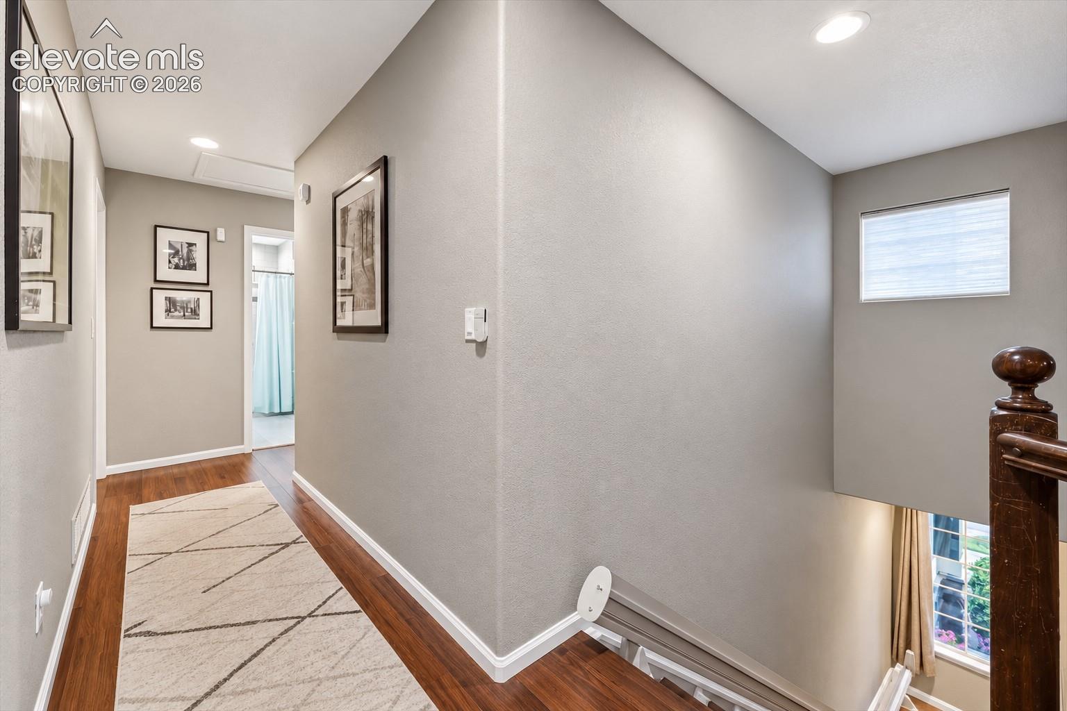 The upper hallway overlooks the main level, emphasizing the home's open architecture and impressive ceiling height.