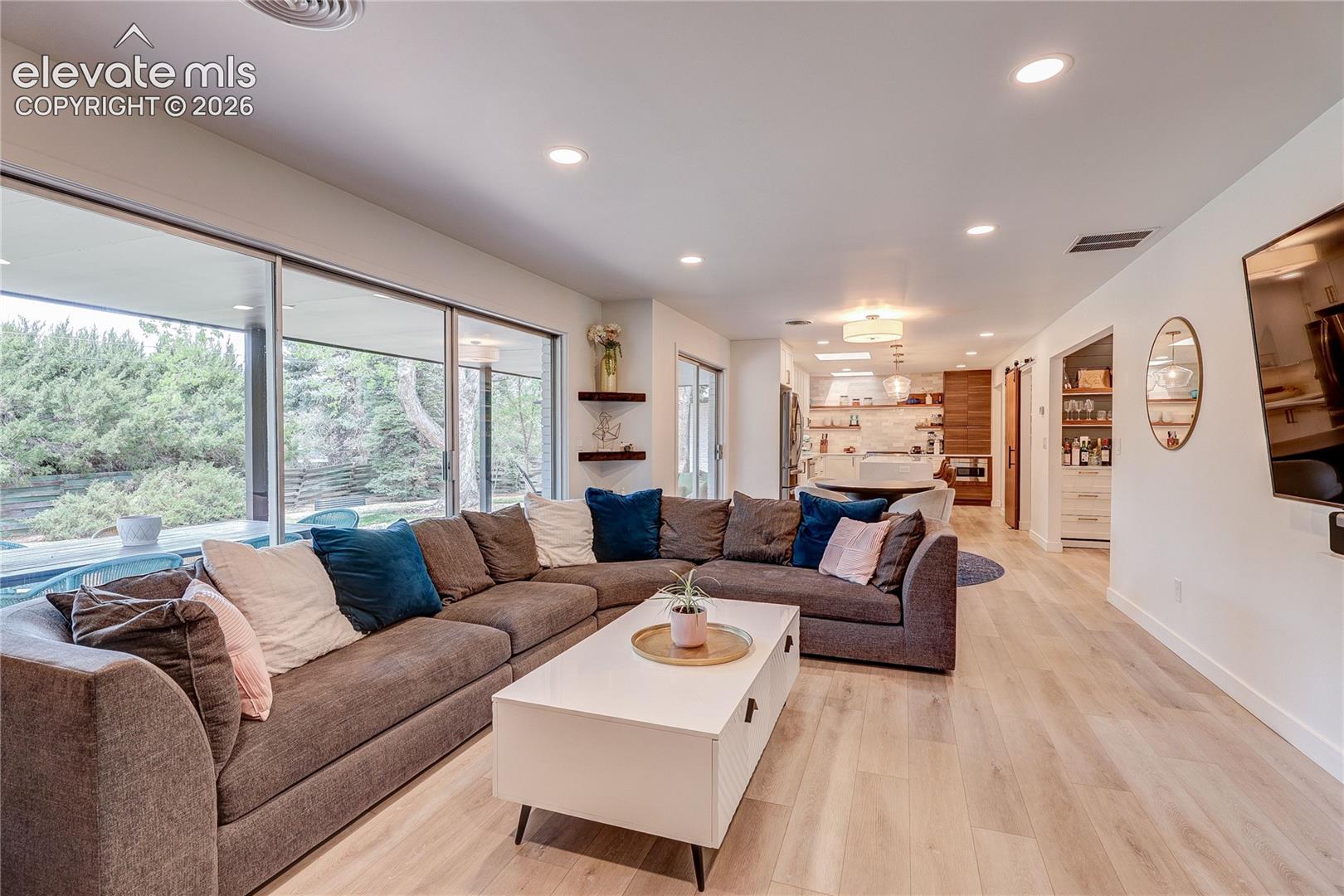 Recessed lighting, wood-finish flooring, and large sliding glass doors