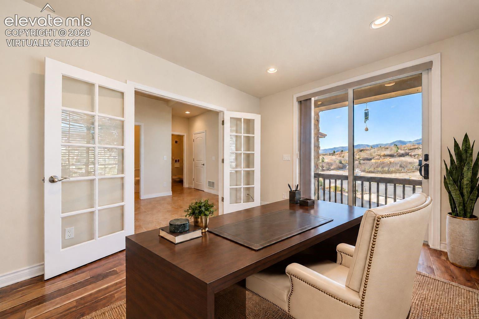 Virtually Staged. Interior space featuring multi-pane glass French doors, recessed lighting, wood-finish flooring, and a sliding glass door with a mountain backdrop