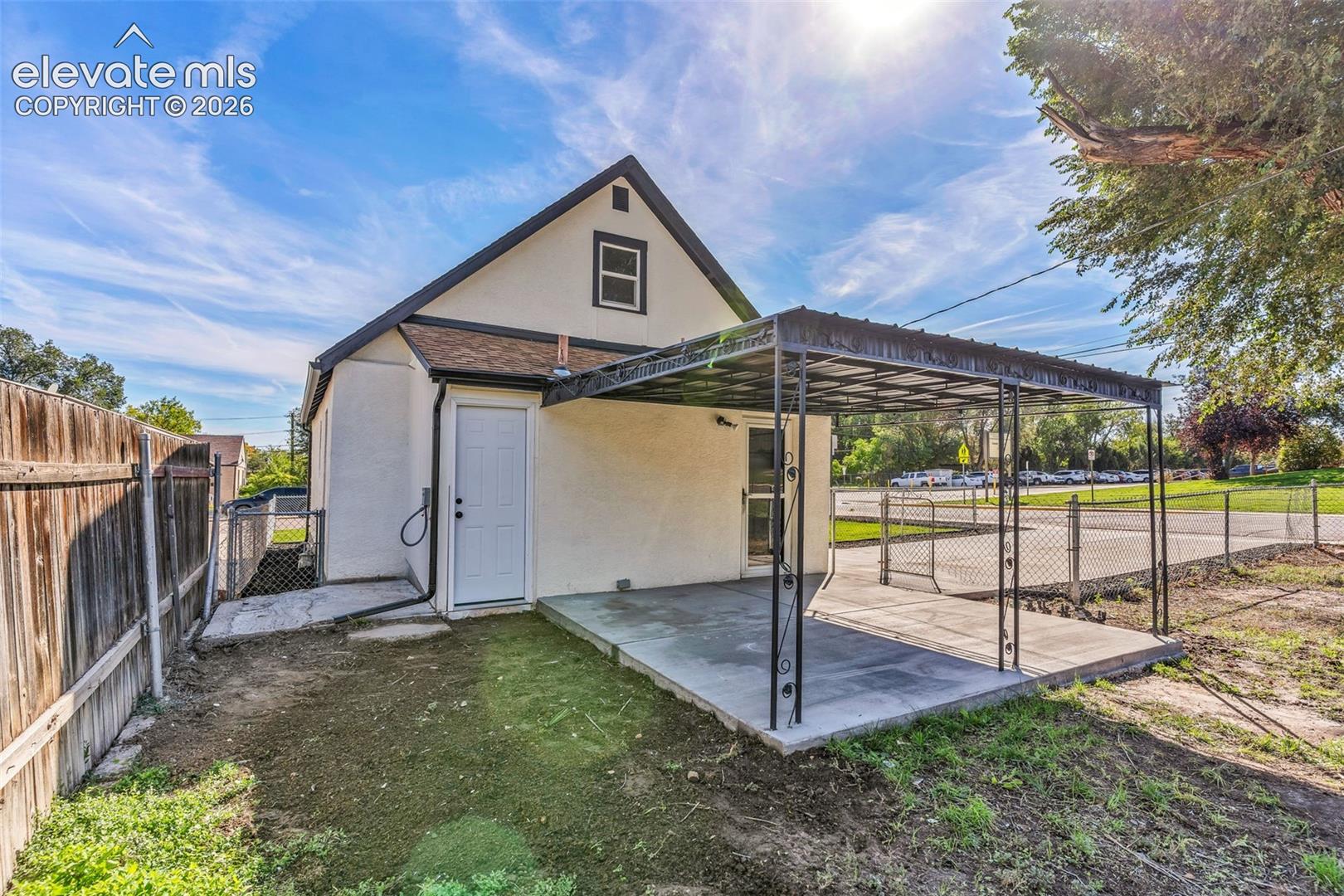 Stucco exterior with a metal-framed covered patio and a concrete slab foundation