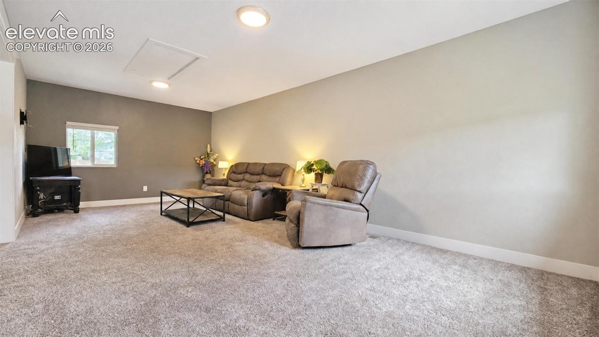 Recessed ceiling lighting, window with white trim, wall-mounted light fixtures, and wall-to-wall carpeting