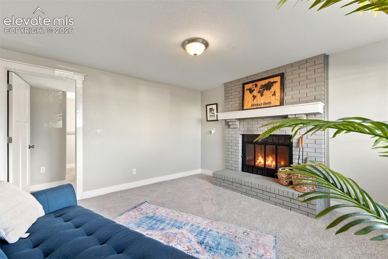 Brick fireplace with a substantial hearth, mantel, and metal firebox