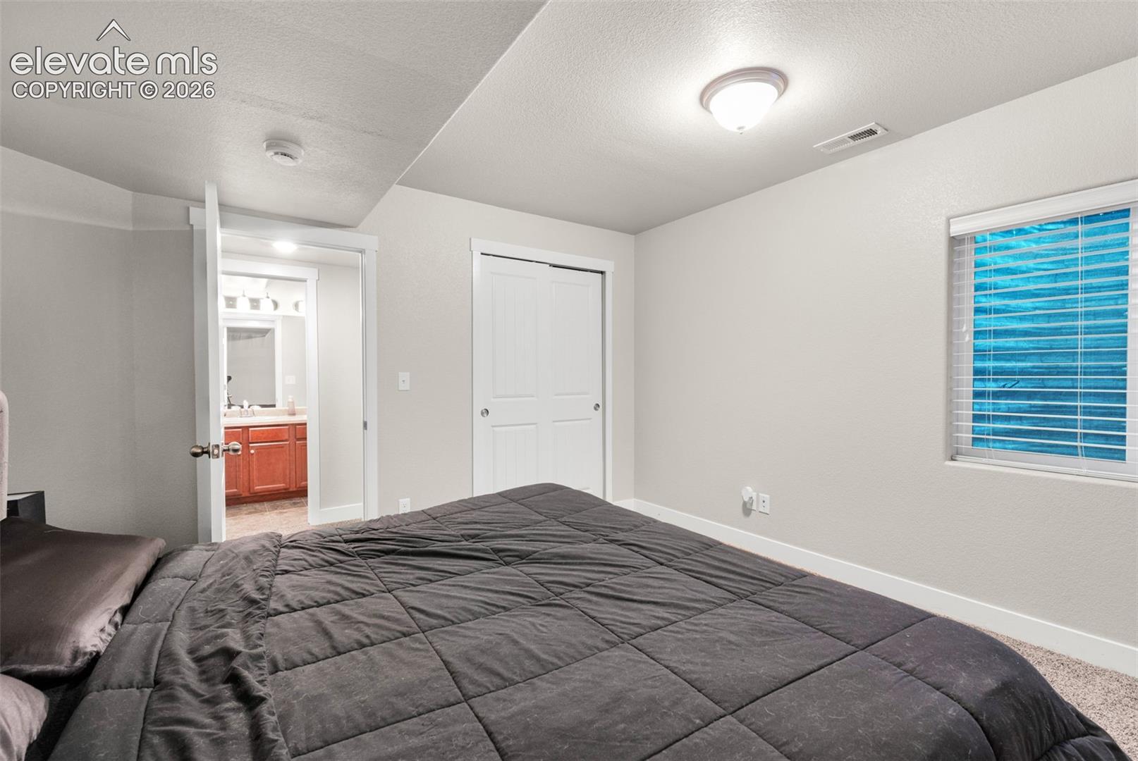 Neutral-toned bedroom featuring recessed ceiling lighting, a closet with double-panel doors, carpeting, and a window with blinds