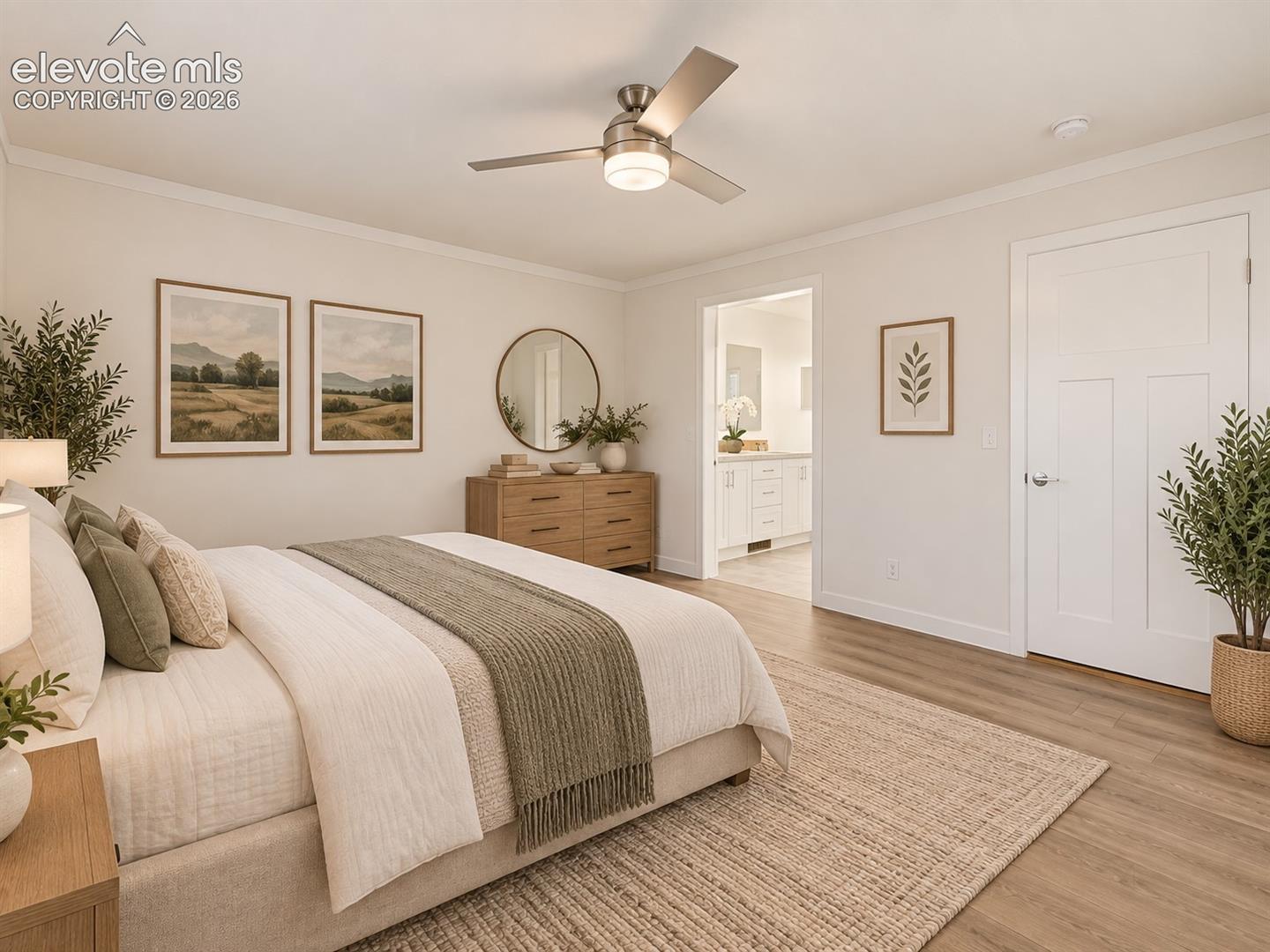 Primary Bedroom – Spacious primary bedroom features wide-plank flooring, a ceiling fan, and convenient access to the adjoining primary bath.