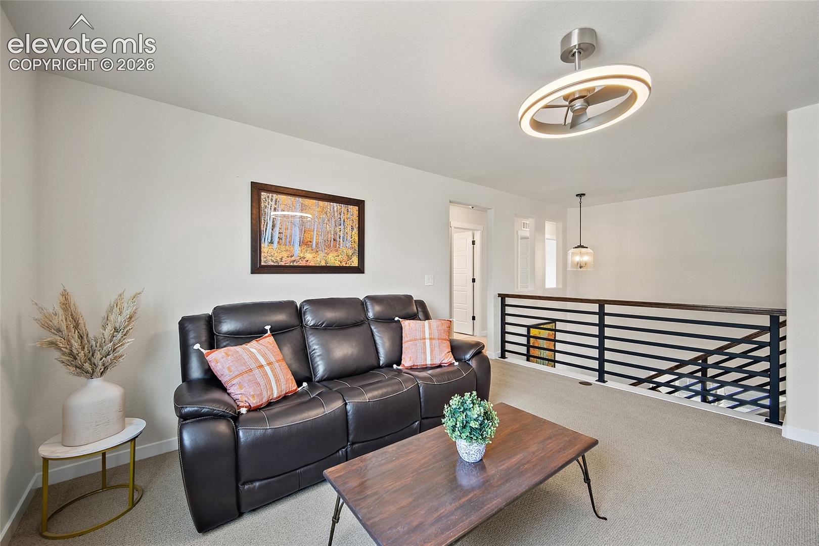 Carpeted loft area featuring a contemporary ceiling fan with integrated lighting, 