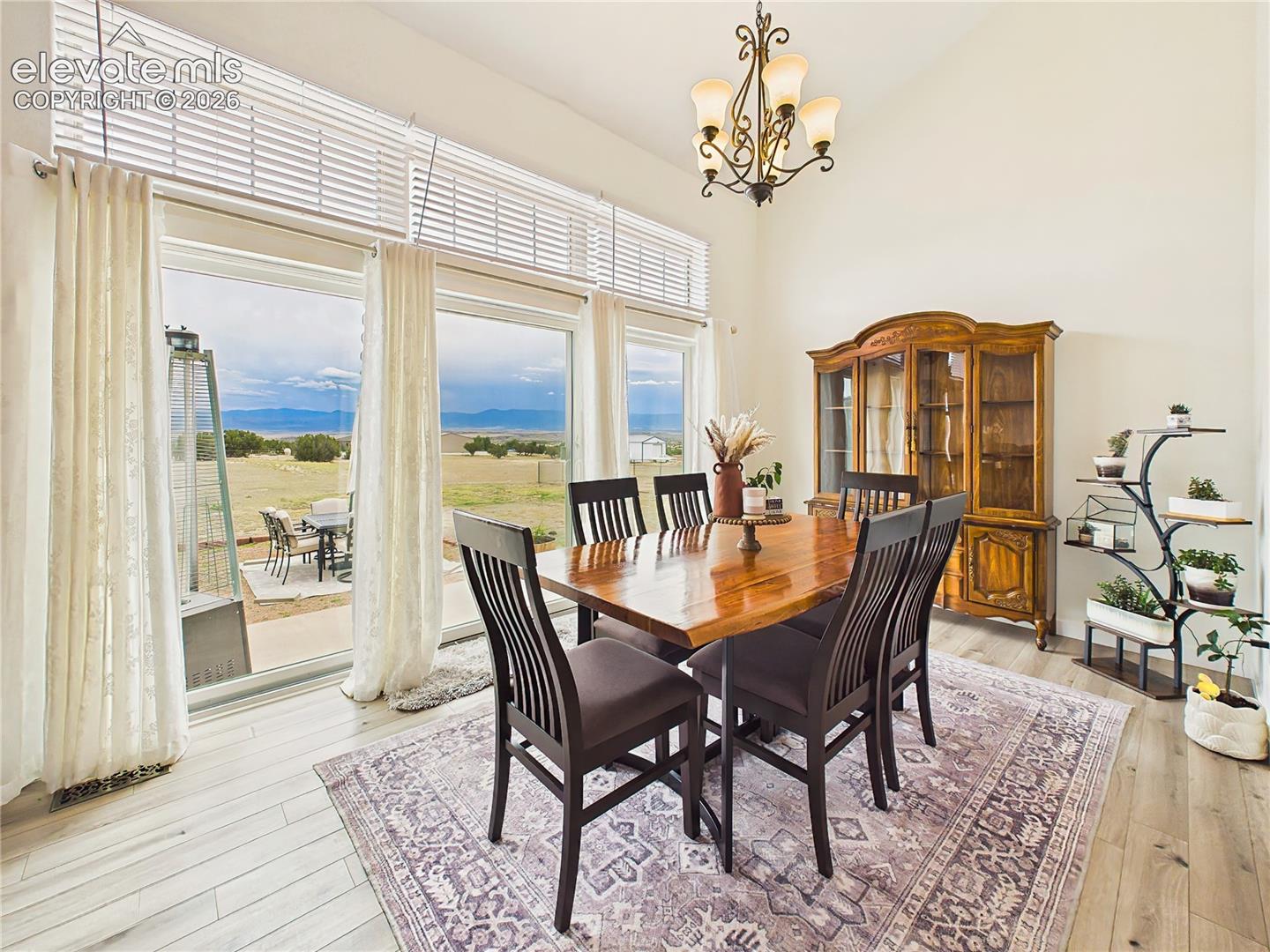 Expansive windows provide a stunning backdrop for dining, seamlessly connecting indoor living with the surrounding landscape.