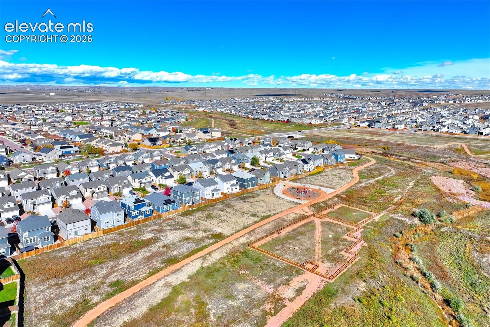 Aerial perspective featuring a network of paved pedestrian paths, a dedicated circular recreational area, and expansive open space