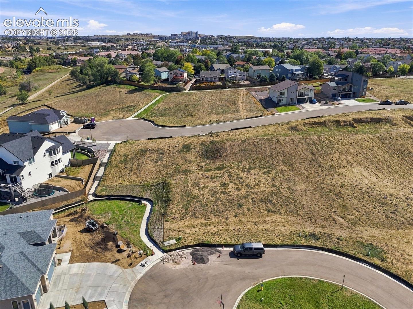 Residential building site with paved cul-de-sac access and established neighborhood surroundings