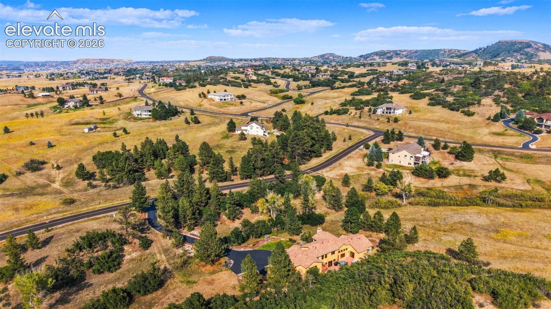 Spacious property with a terracotta tile roof, surrounded by mature evergreen trees