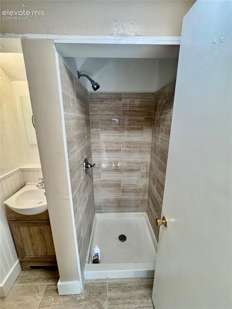 Tiled shower stall with a matte black shower head and hardware