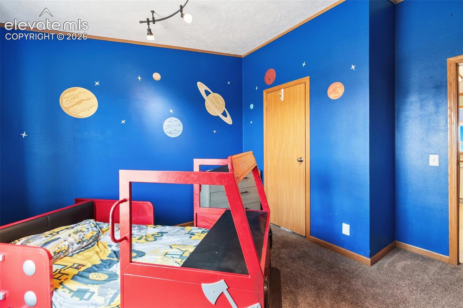 3rd bdrm carpeted room with blue walls, a window featuring an expansive sky, and built-in shelving