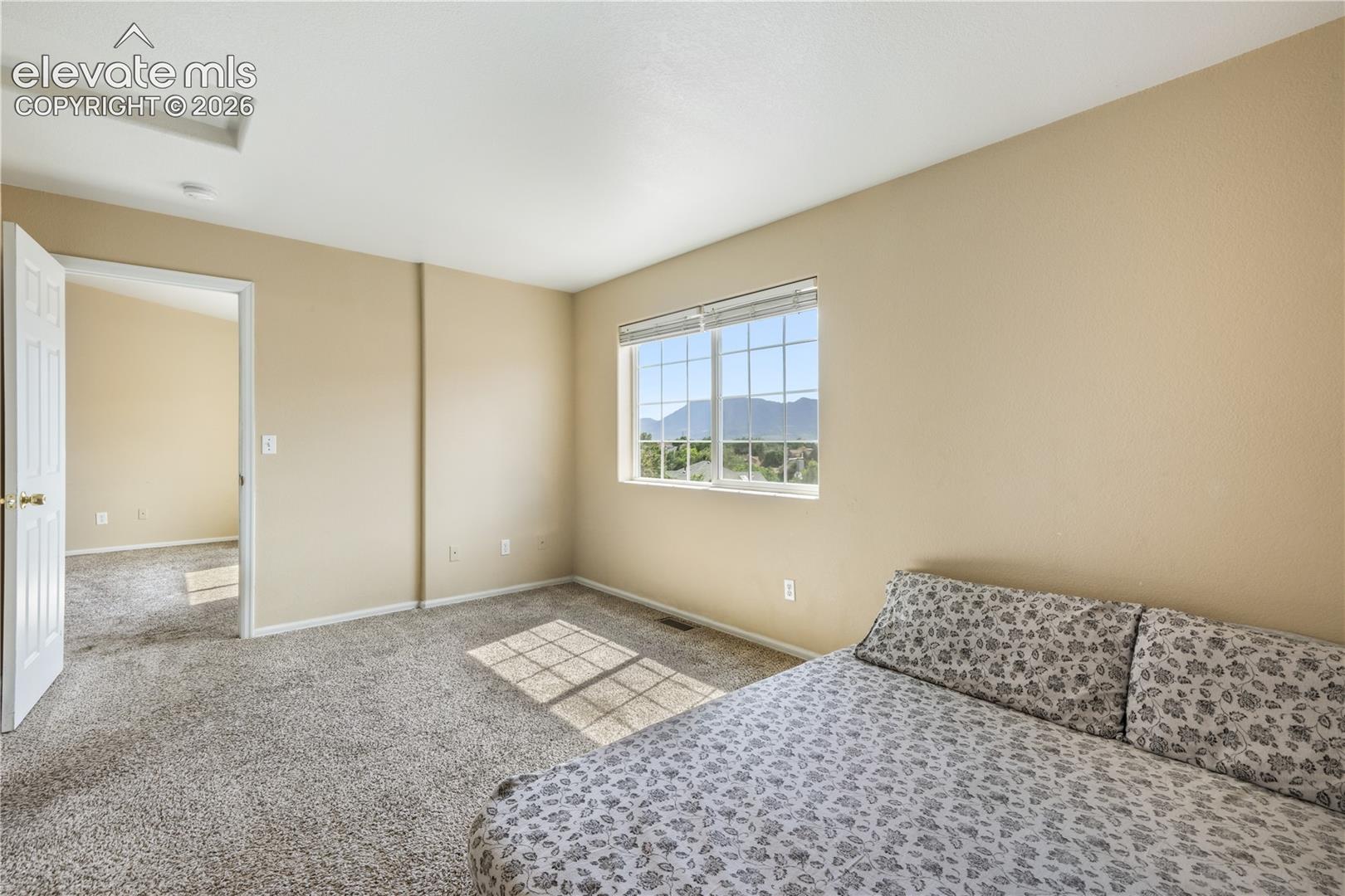 Main level primary bedroom with walk in closets and ensuite bathroom with 2 vanities, 2 separate showers