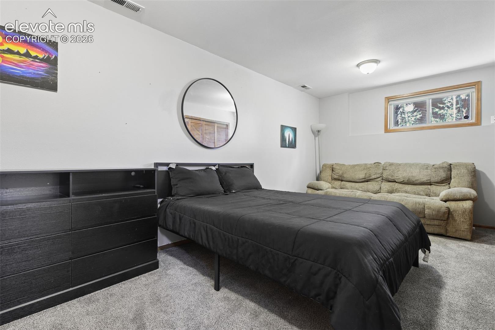 Carpeted room with a window featuring wood trim, a built-in light fixture, and white painted walls