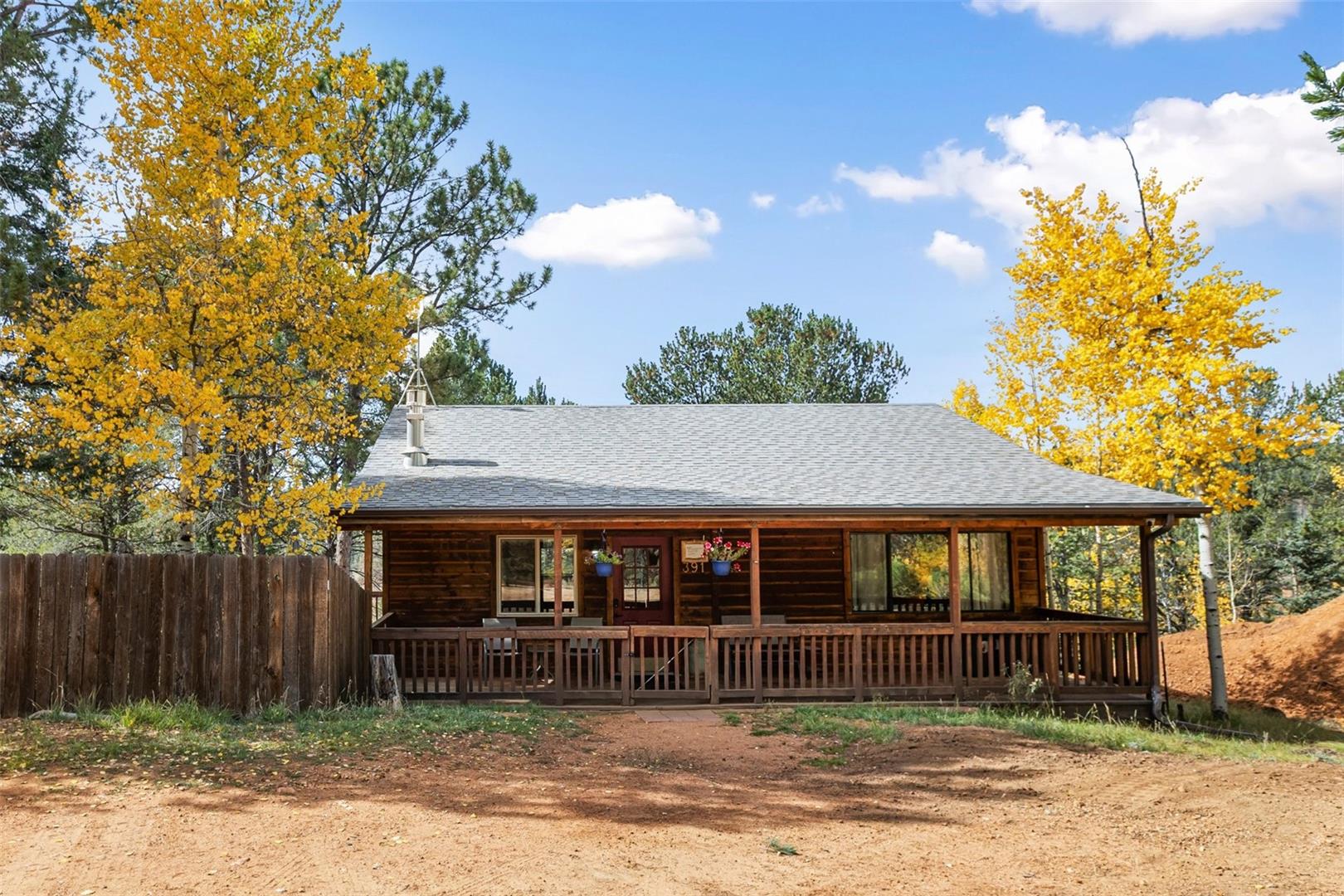 Wood-sided residence featuring a covered front porch with a wooden railing