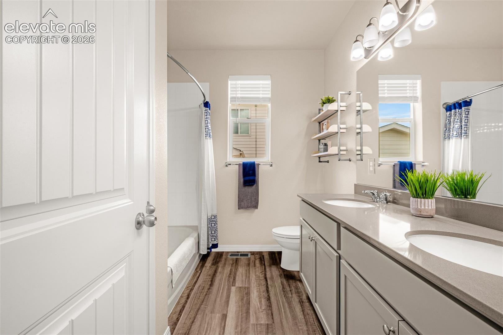 Dual vanity with undermount sinks, gray cabinetry, and light-toned countertops