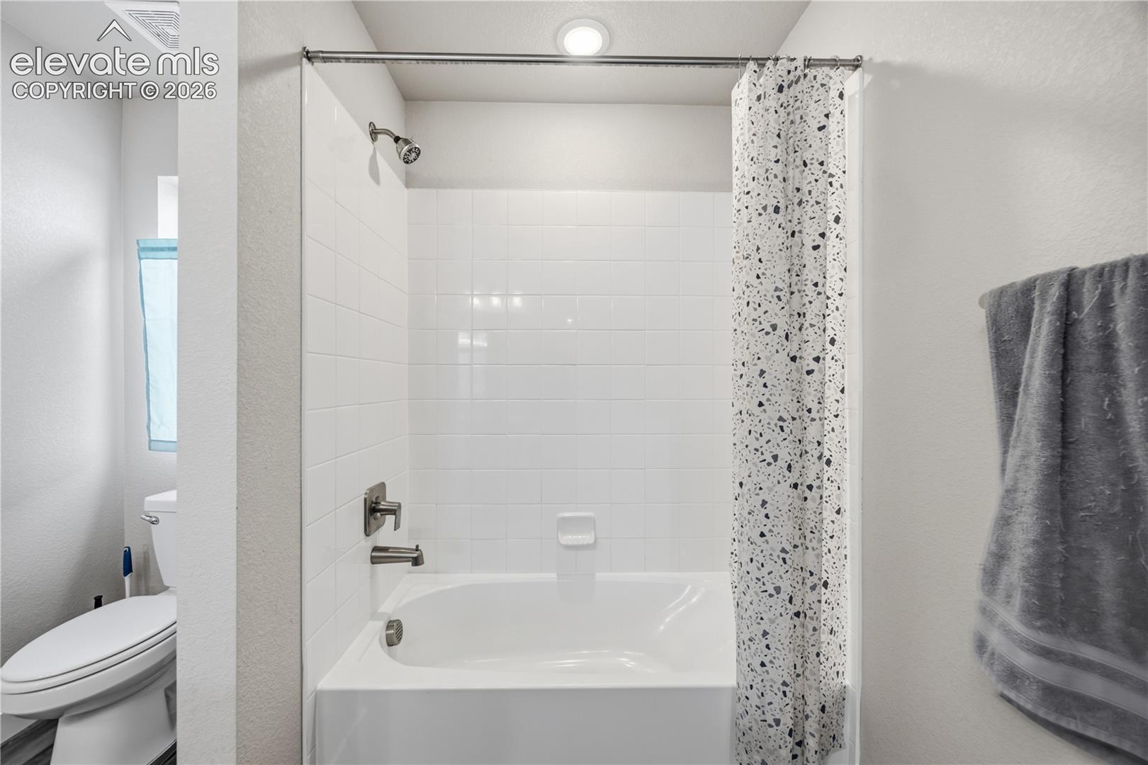 Tiled tub/shower in the upper level Hall Bathroom.