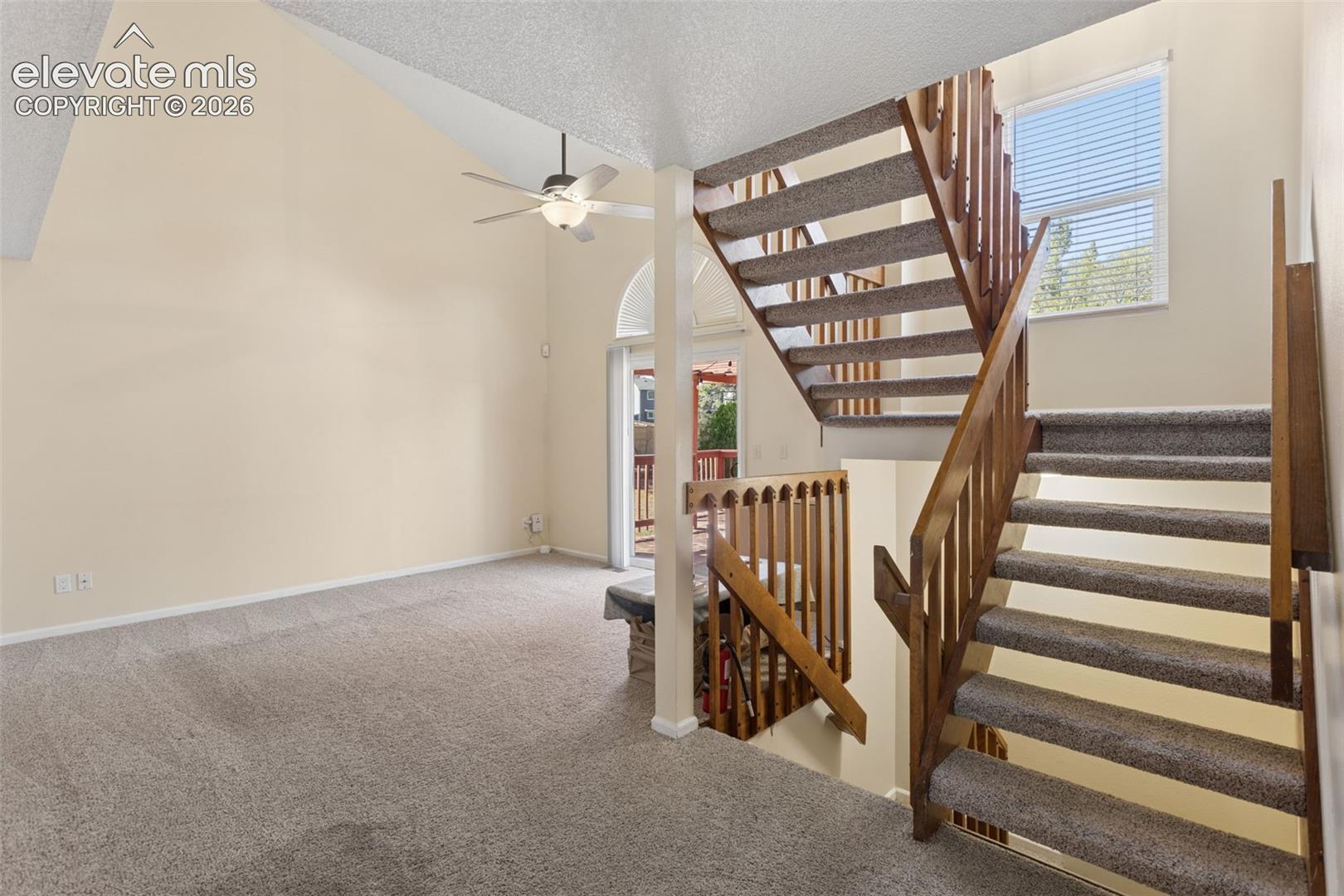 Living Room with vaulted ceiling with a ceiling fan