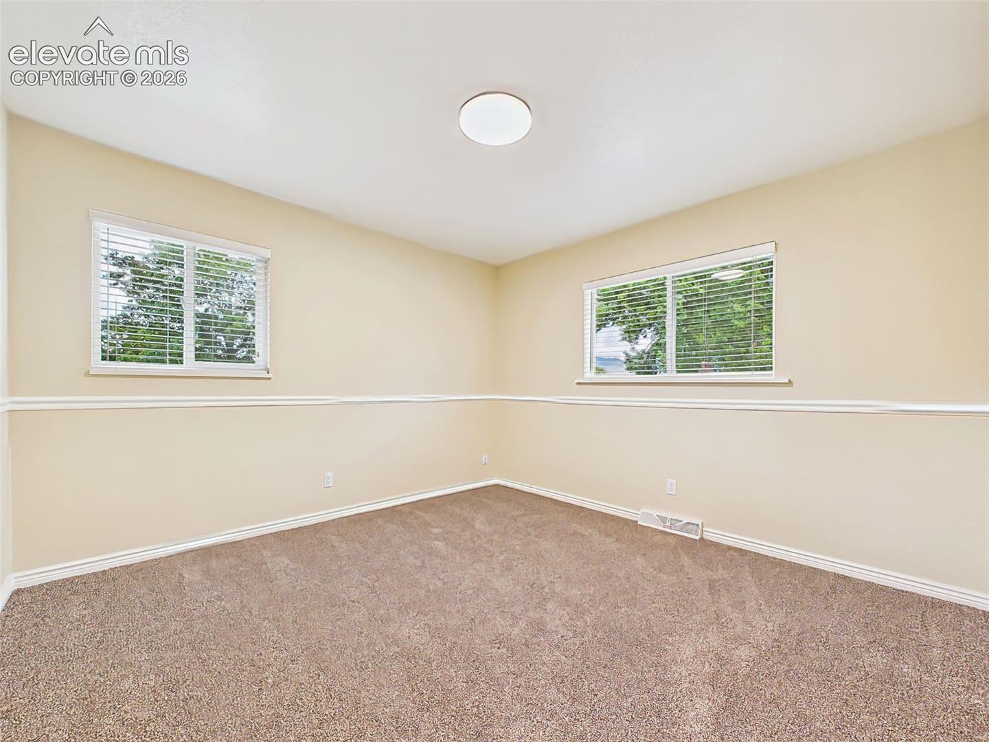 Bright and comfortable secondary bedroom with brand-new carpet, large windows, and a versatile layout ideal for guests, family, or a home office.