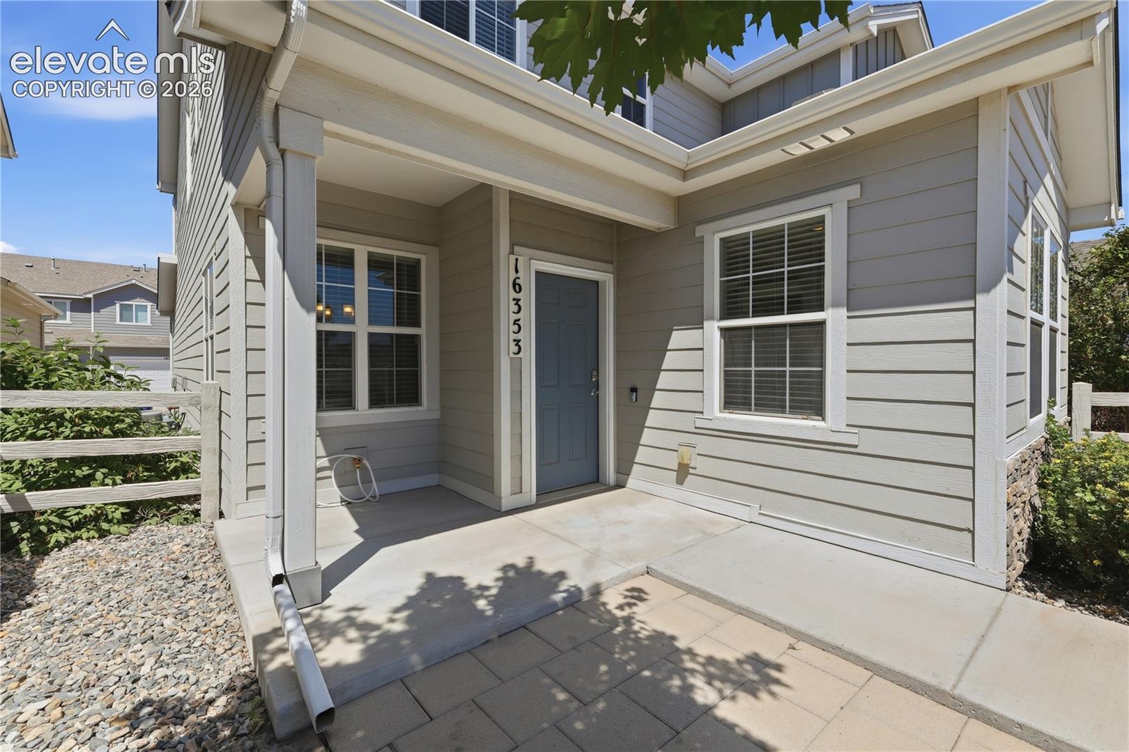 Inviting covered porch with a slate blue entry door