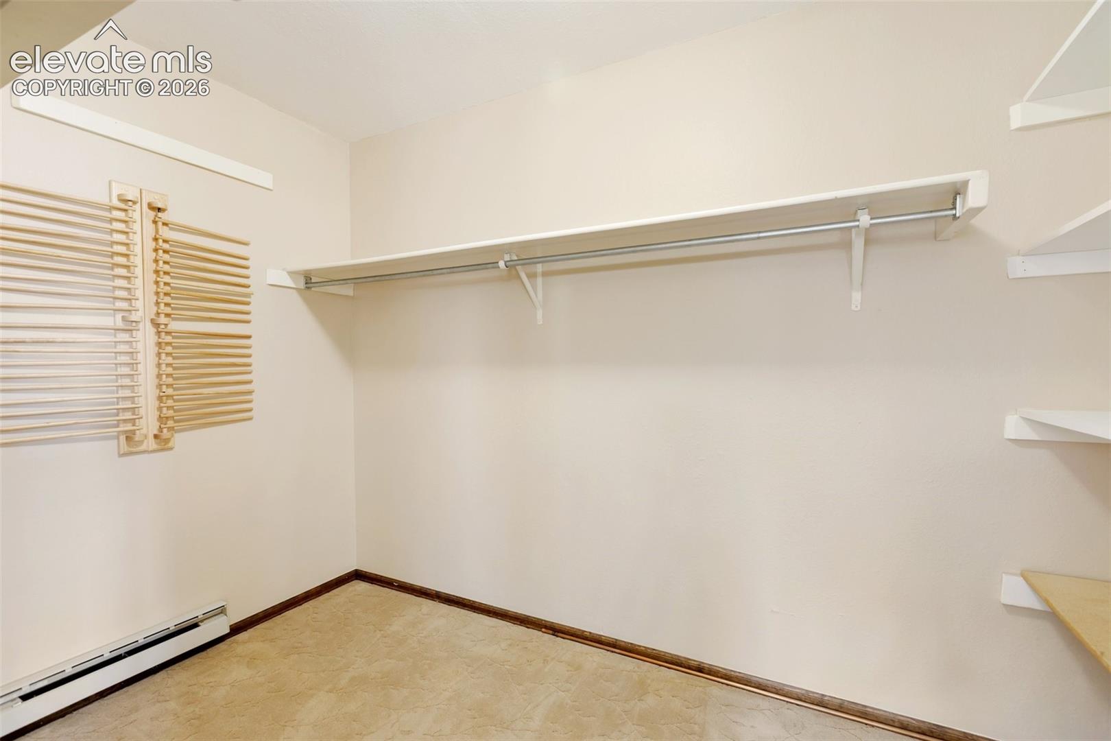 Built-in closet shelving, integrated hanging rod, and wall-mounted wooden blinds
