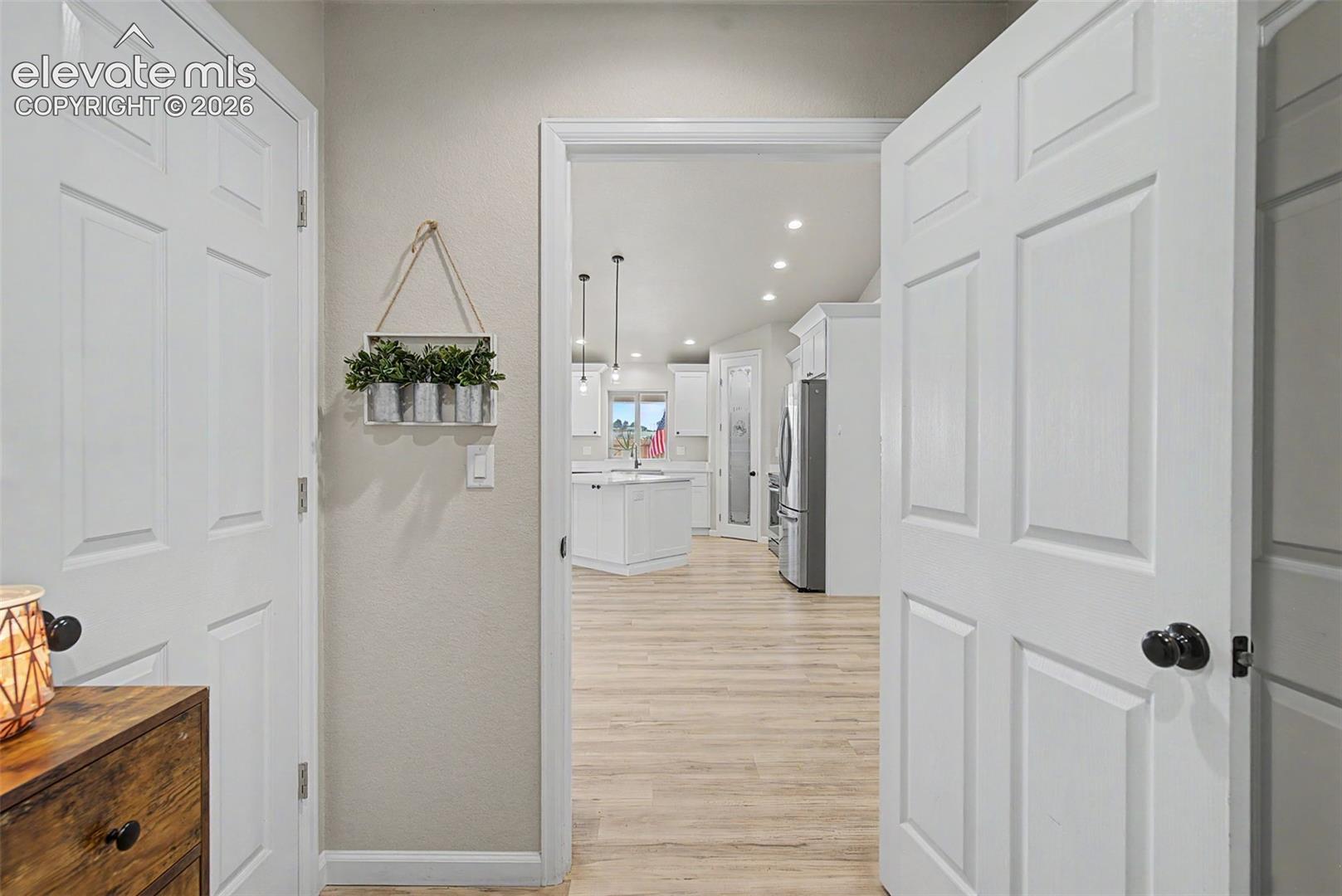 Open-concept living area with vaulted ceilings, recessed lighting, and wood-finish flooring
