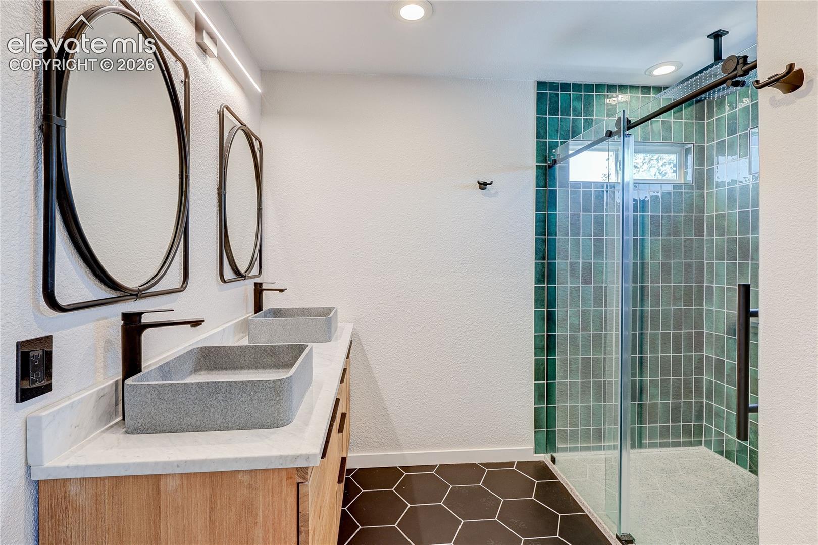 Beautifully remodeled primary bath with 2 sinks and large walk-in shower.