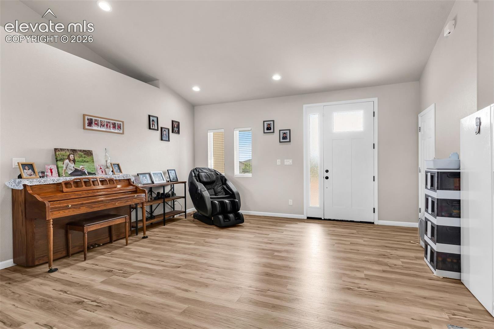 Entry foyer with woo-finish flooring, recessed lighting, and vaulted ceilings