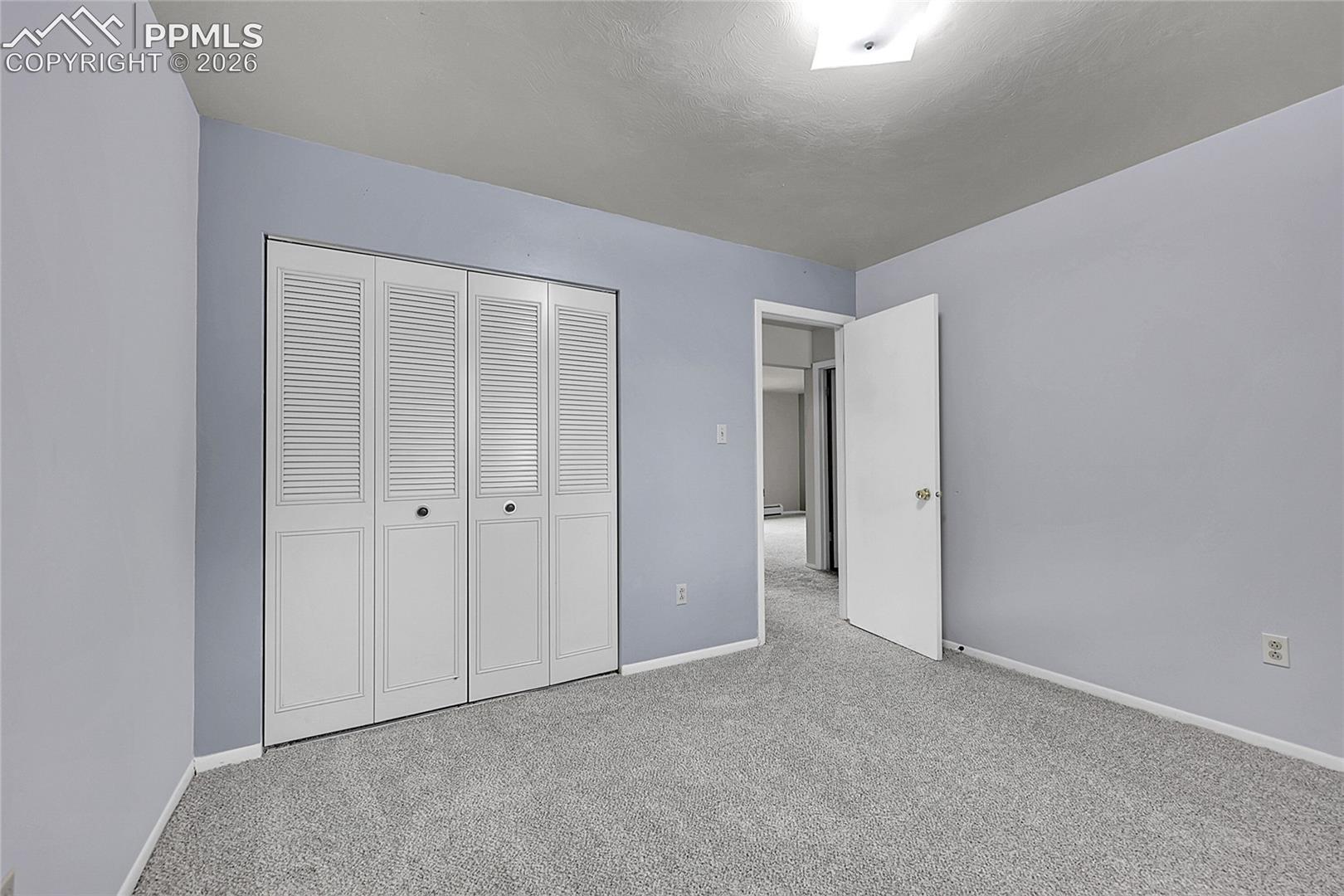 Unfurnished bedroom featuring carpet and a closet