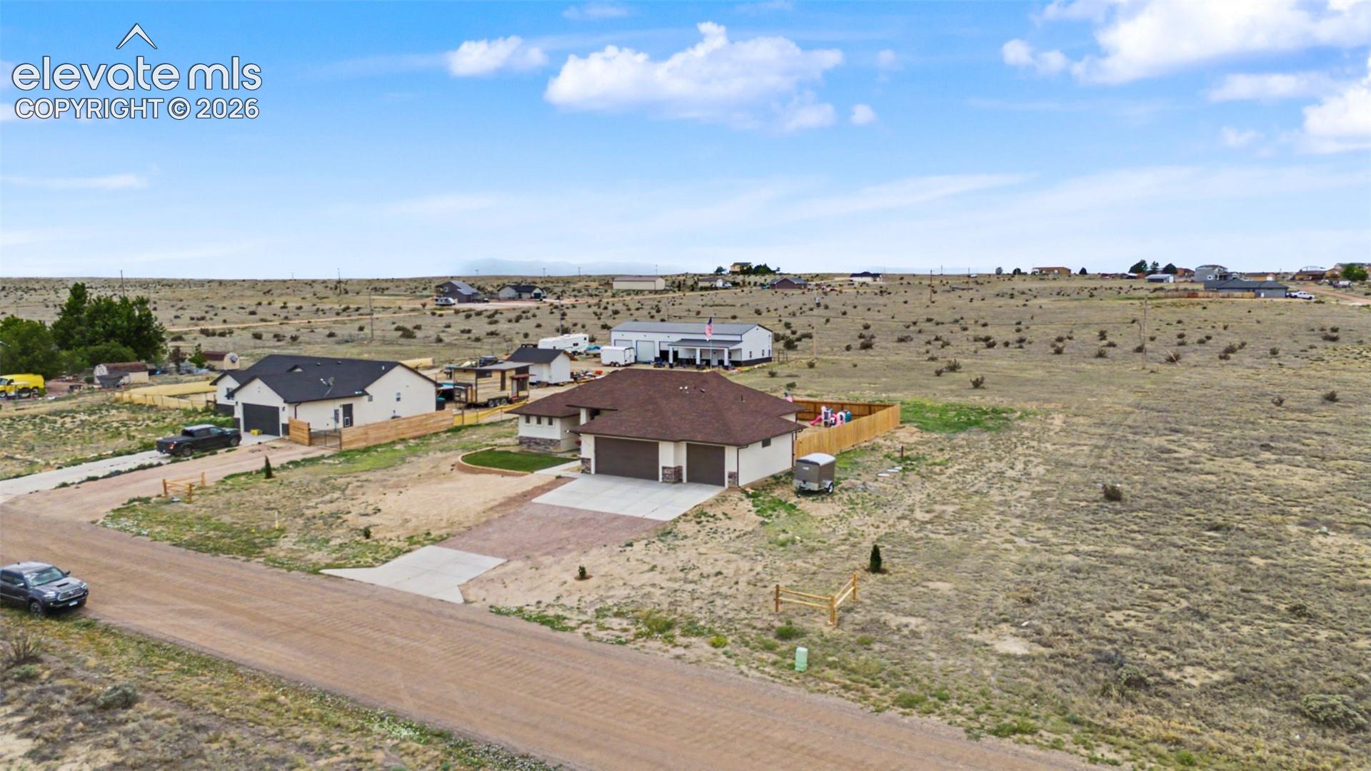 Contemporary ranch-style home featuring a two-car garage, concrete driveway, and a fenced backyard