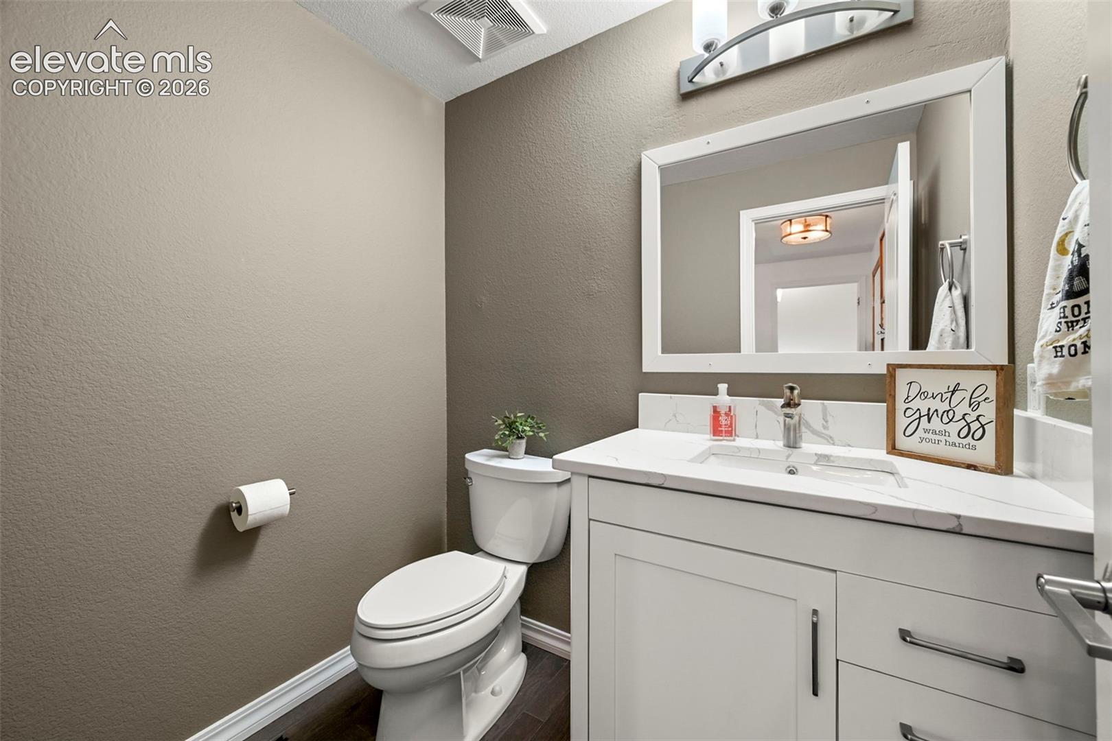 White vanity with a rectangular undermount sink, a white countertop, and modern hardware