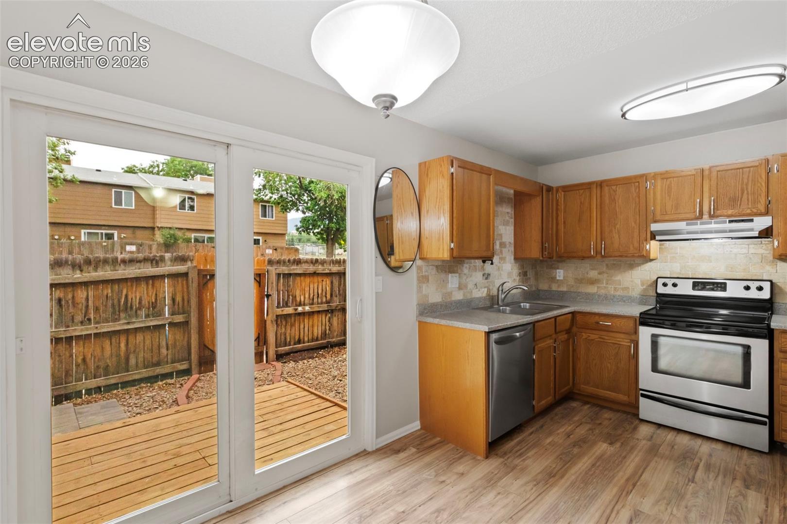 Step from the kitchen and dining area to the newer wood deck in the enclosed patio