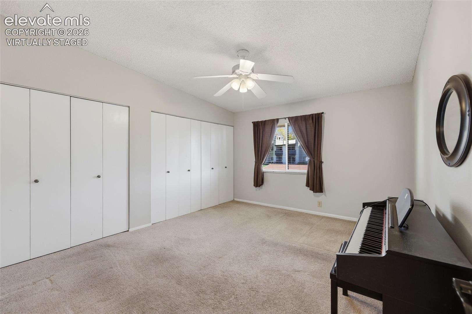 virtually staged. Bedroom featuring neutral wall paint, wall-to-wall carpeting, and a single-pane window with a curtain rod
