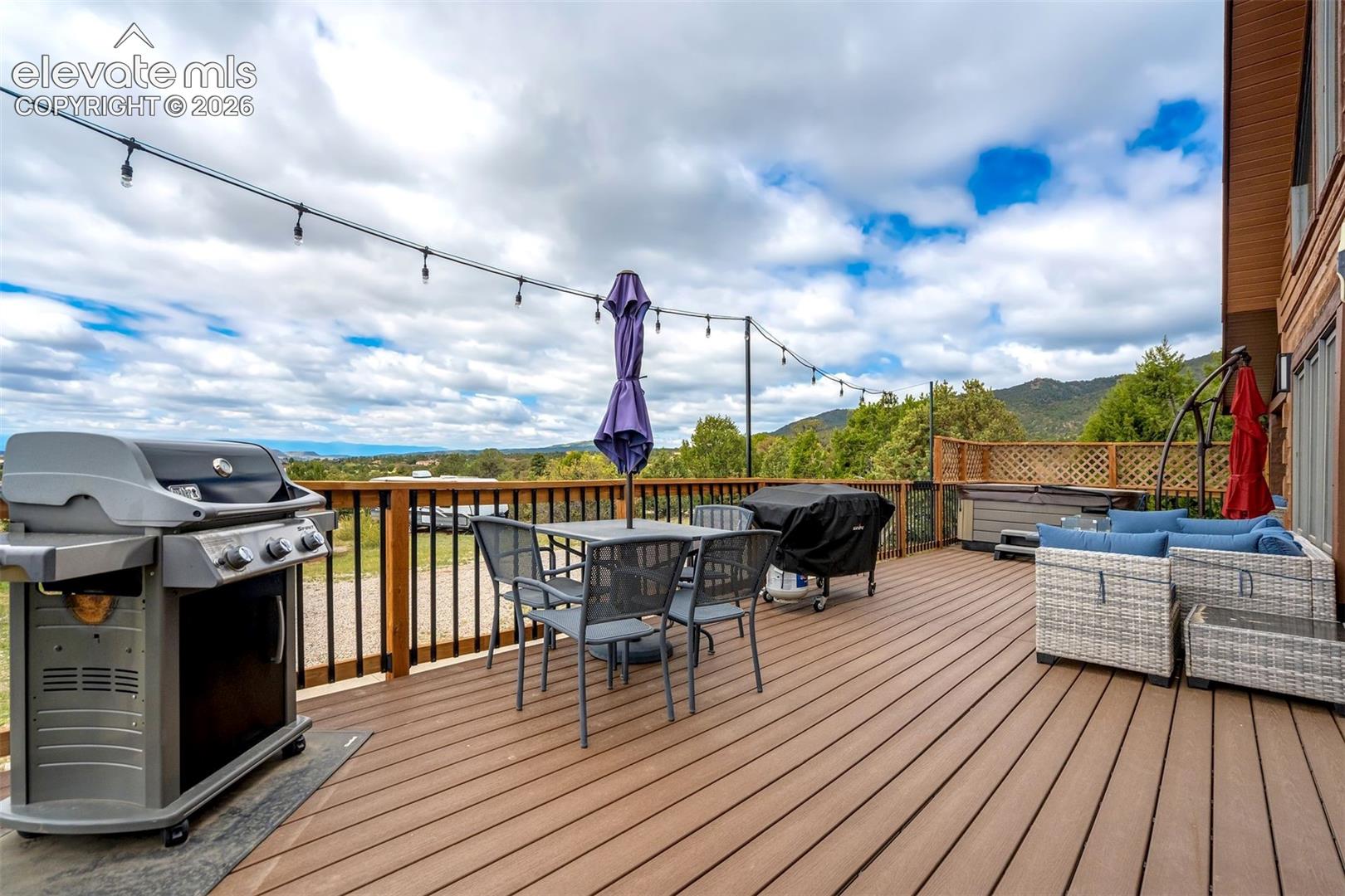 Expansive outdoor deck featuring wood-finish flooring and black metal railings