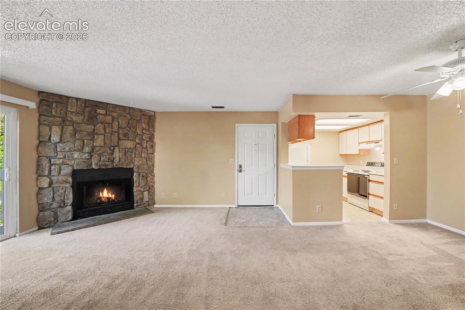 Living room with stone surround wood burning fireplace