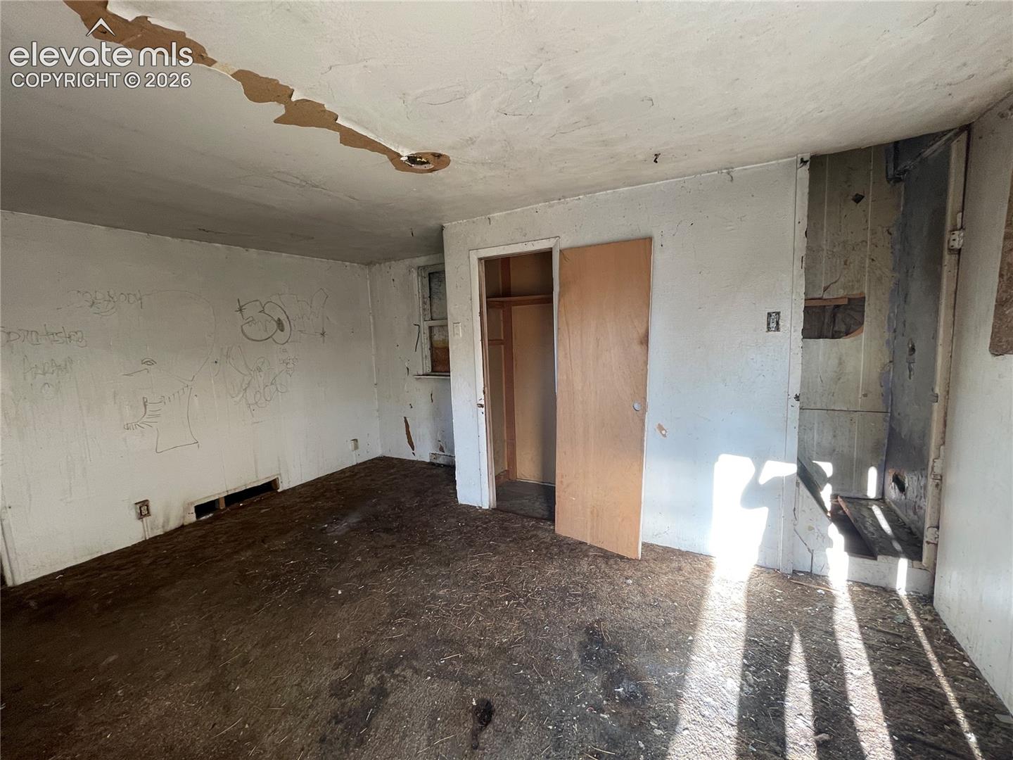Interior space featuring a wooden door, built-in closet, and window