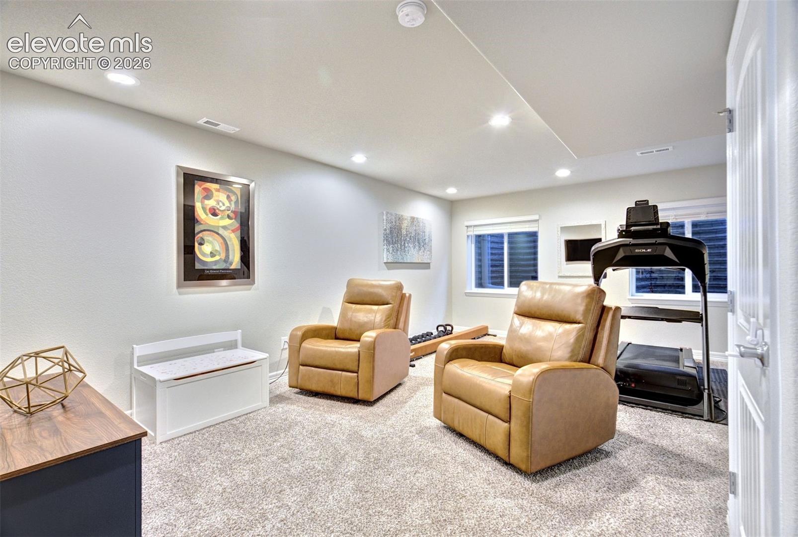 Neutral-toned interior space featuring recessed ceiling lighting, wall-to-wall carpeting, and dual inset windows