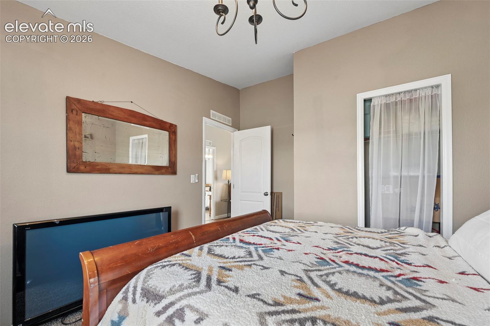 Neutral interior wall color with an arched-arm metal light fixture and a multi-panel interior door