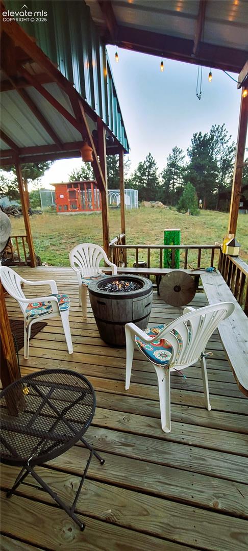 Expansive wood-plank deck with a covered area, exposed timber frame, and string lighting