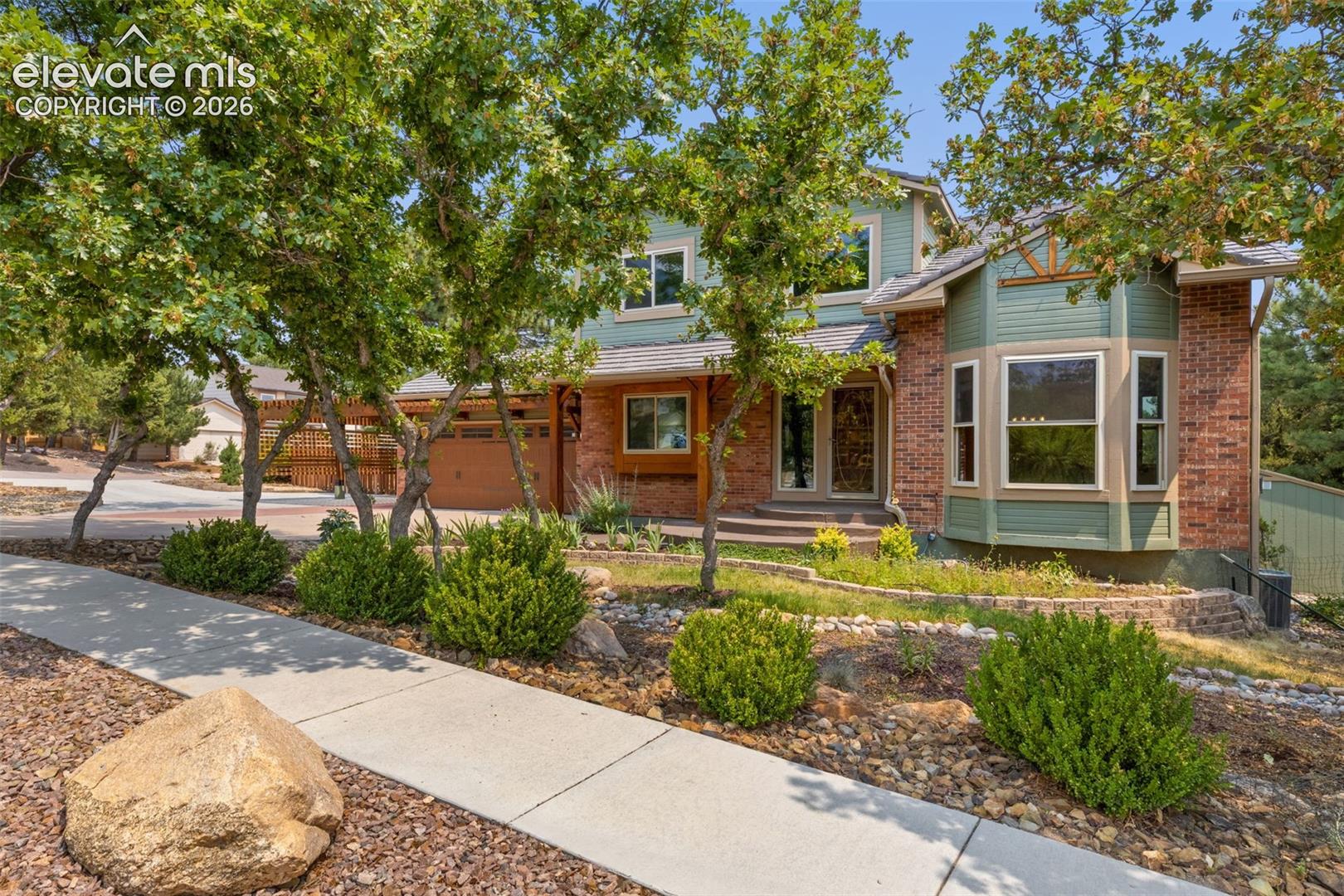 Welcome to this exceptional home in the highly sought-after Broadmoor Bluffs neighborhood, where breathtaking Cheyenne Mountain views, an unbeatable location, and impeccable pride of ownership come together. Situated on a premium corner lot just a short walk to award-winning Cheyenne Mountain Elementary, this immaculate property offers the perfect blend of comfort, functionality, and Colorado living. The inviting interior features soaring ceilings, rich hardwood floors, a sunken Great Room with exposed beam ceiling, bay window, and cozy wood-burning stove. The chef's kitchen is designed for entertaining with a stunning 7-foot leathered granite island, stainless steel appliances, wine refrigerator, pantry, and walk-out access to the expansive composite deck. Just out your door, enjoy spectacular mountain views, a large backyard, and a sunken hot tub, perfect for relaxing or hosting guests. Parking is exceptional with a finished two-car garage featuring an EV charger, two-car pergola carport, RV/extra vehicle parking pad, and a circular driveway with access from both Farthing and Lowick. The luxurious primary suite offers vaulted ceilings and a private, spa-inspired bath with heated floors, soaking tub, skylight, oversized shower, granite countertops, and a spacious walk-in closet. The lower garden level provides an ideal second primary suite complete with adjoining bath and large walk-in closet. This level also features a wet bar, family room, 2nd bedroom, and abundant storage making it ideal for guests or multi-generational living. Additional highlights include newer triple-pane windows, a Class 4 DaVinci Bellaforte impact-resistant roof, 10x12 Tuff Shed, main level laundry room, and thoughtful upgrades throughout. Every detail reflects meticulous care, making this home truly move-in ready. Experience the best of Broadmoor Bluffs with stunning views, top-rated schools, incredible parking, no HOA, and a home that has been lovingly maintained inside and out.