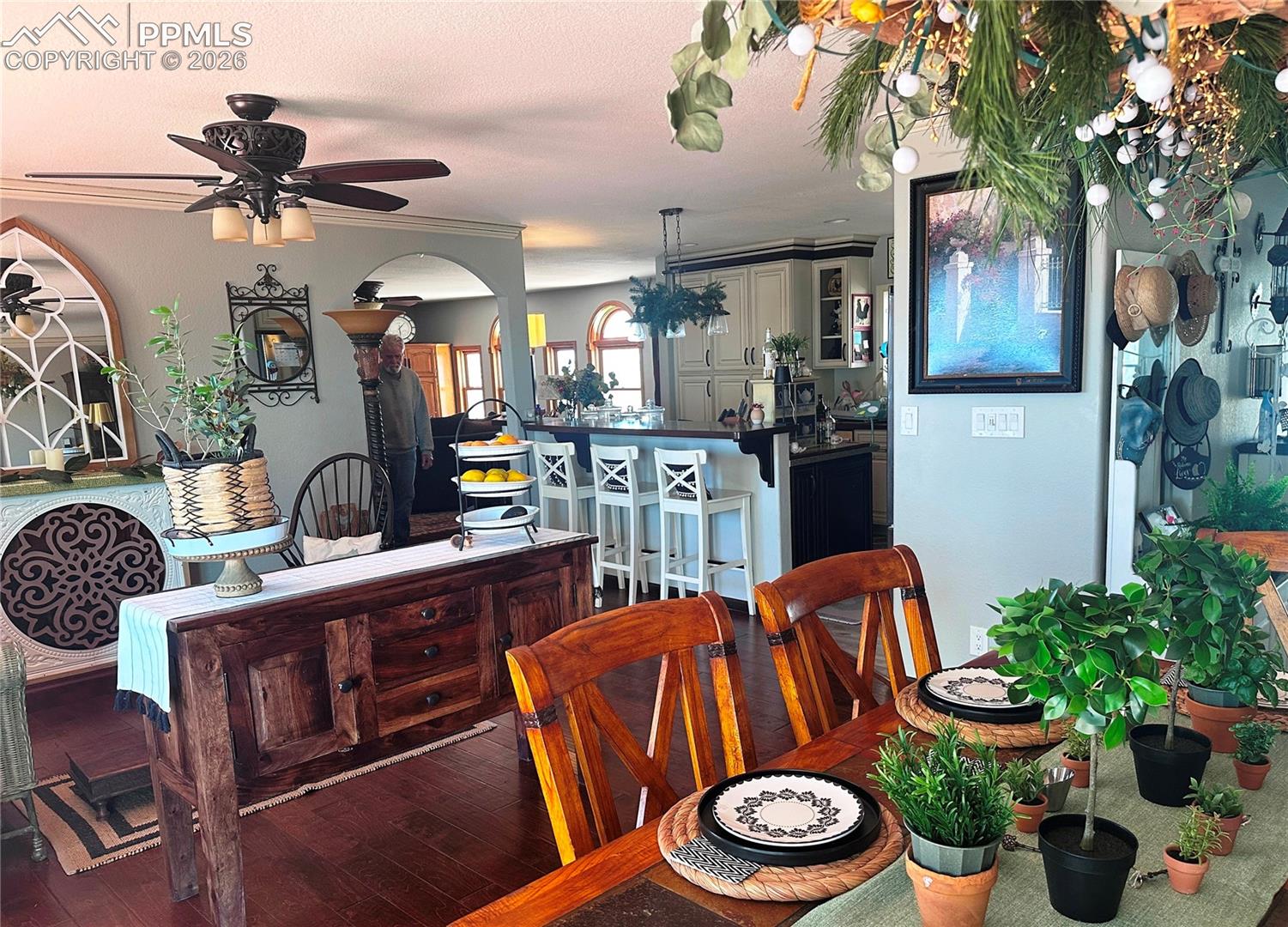 View of sitting area at left, living room at top and kitchen area with breakfast bar at right.
