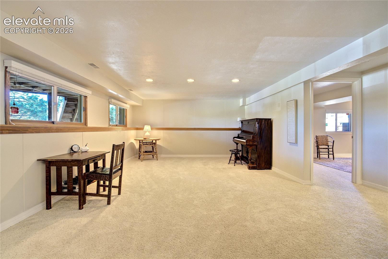 Above-grade windows welcome natural light into the spacious recreation room, creating a lower level that feels open + inviting.