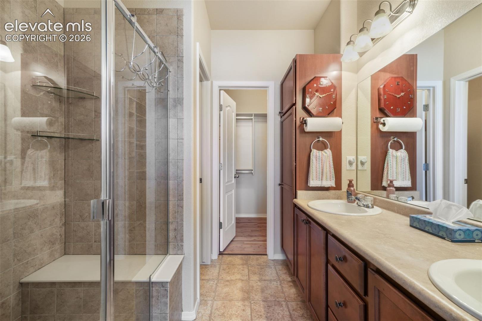 Glass-enclosed shower with a built-in bench and tiled walls