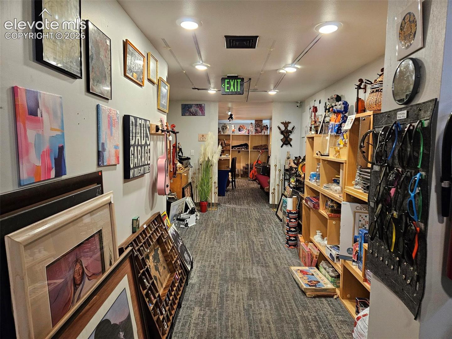Middle room, recessed ceiling lighting, wood-finish shelving units, and carpeting