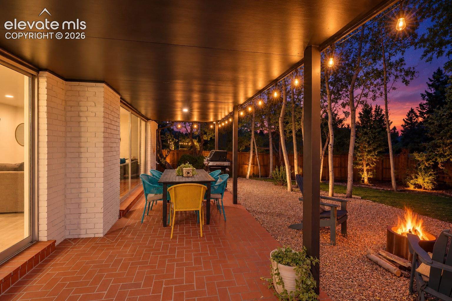 Covered patio featuring a brick paver surface, string lighting, and ample space for outdoor seating