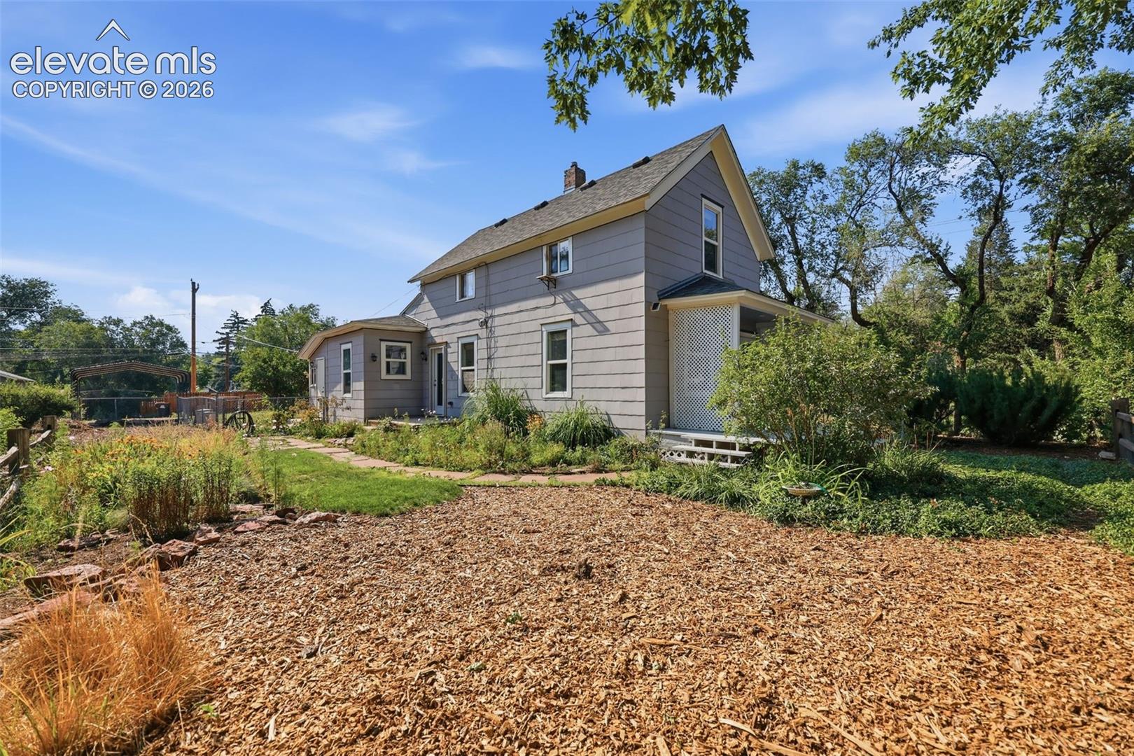 Exterior featuring flowerbeds, horizontal siding and white trim windows.