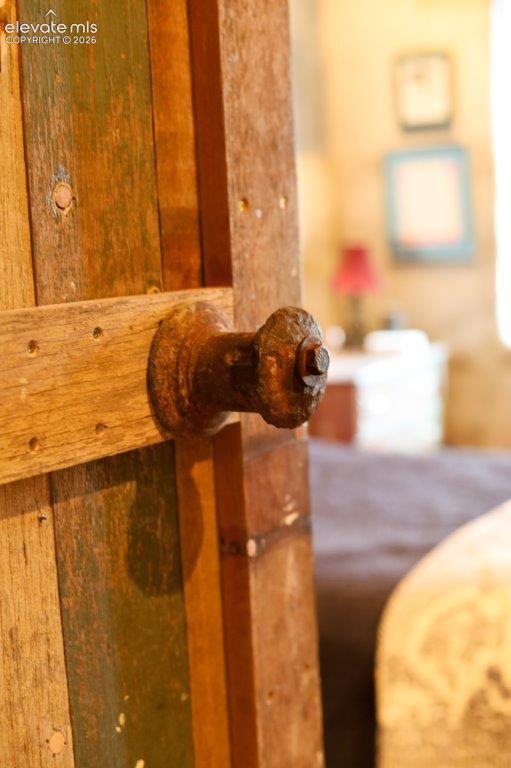 Wooden plank door featuring a rustic metal knob