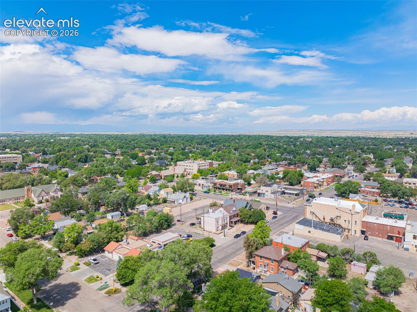 Expansive aerial perspective showcasing a neighborhood with mature tree coverage
